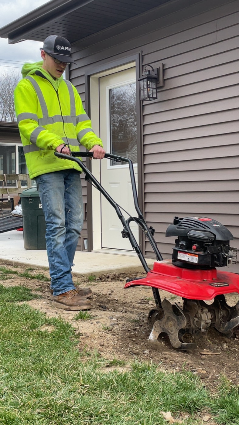 Yardigans team member handling lawn equipment at a home