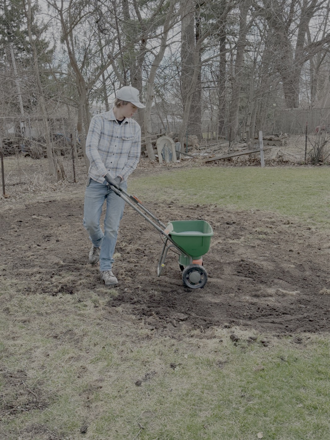 Yardigans team member handling yard work with a spreader